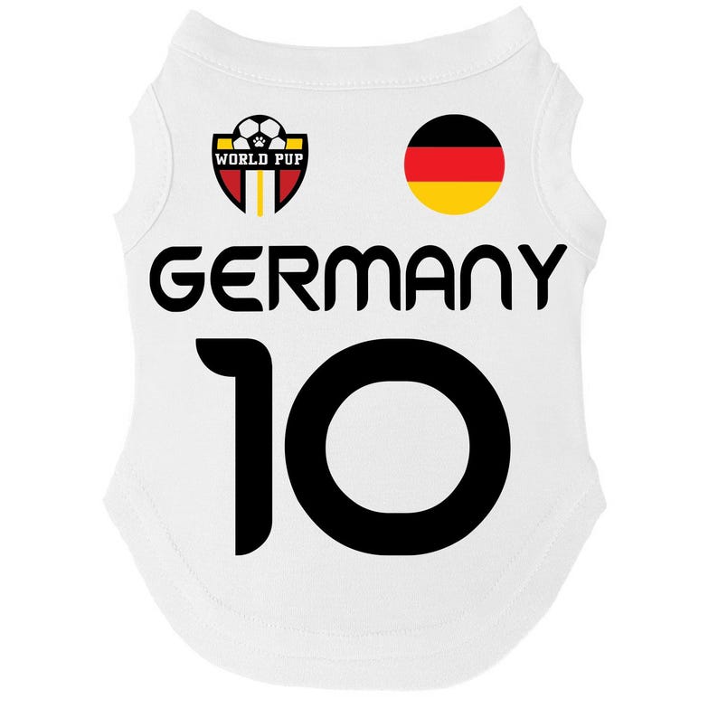 Puede incluir: Camiseta blanca para mascotas con la palabra "GERMANY" en letras negras grandes y el n&uacute;mero "10" debajo. La camiseta presenta un emblema de la bandera alemana y un logotipo de "WORLD PUP" con un bal&oacute;n de f&uacute;tbol.