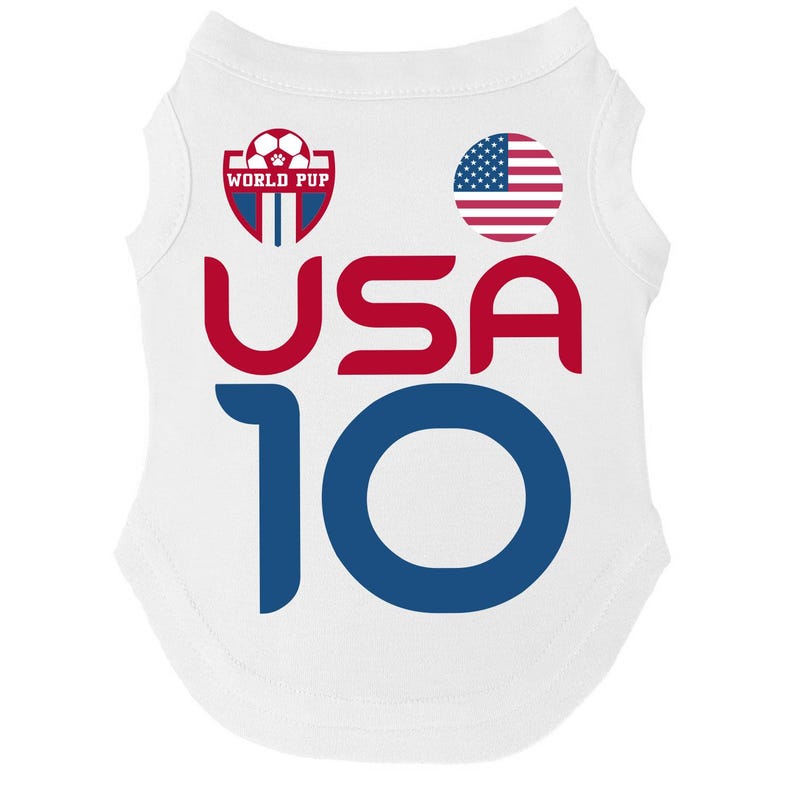 Puede incluir: Camiseta blanca para mascotas con el texto "USA 10" en rojo y azul. La camiseta presenta una bandera americana y un logotipo que dice "World Pup" con un bal&oacute;n de f&uacute;tbol y una huella de pata.