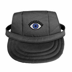 May include: A dark gray baseball cap featuring an embroidered eye design with a blue iris and white accents. The cap has a curved brim and an adjustable strap. The eye symbol is centered on the front of the cap.
