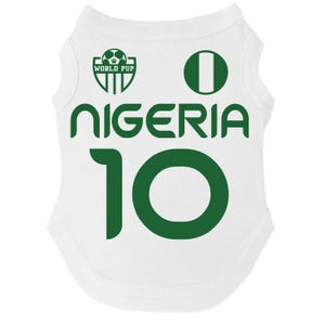 Puede incluir: Camiseta blanca para mascotas con texto y gr&aacute;ficos verdes. La camiseta muestra la palabra "NIGERIA" y el n&uacute;mero "10" en verde. Tambi&eacute;n se ve un c&iacute;rculo verde y un logotipo que dice "WORLD PUP".