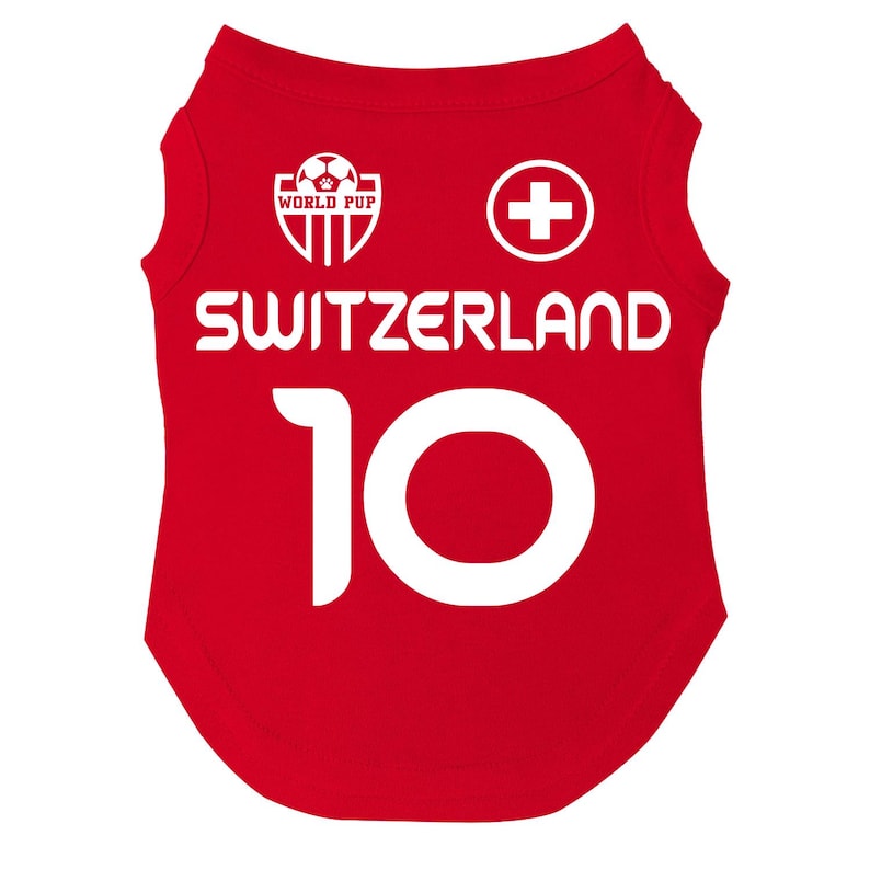 Puede incluir: Camiseta roja para perro con la palabra "SWITZERLAND" en blanco y el n&uacute;mero "10". La camiseta tambi&eacute;n presenta una cruz suiza blanca y un logotipo de "WORLD PUP".