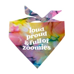 May include: A tie-dye dog bandana with the words "loud proud & full of zoomies" in white. The bandana features a vibrant mix of colors, including pink, yellow, blue, and purple, creating a colorful and eye-catching design.