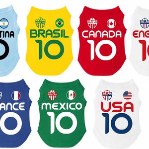 Puede incluir: Una colecci&oacute;n de camisetas para mascotas con tem&aacute;tica de f&uacute;tbol. Cada camiseta es de un color diferente y representa a un pa&iacute;s: Argentina, Brasil, Canad&aacute;, Inglaterra, Francia, M&eacute;xico y EE. UU. Cada camiseta tiene el n&uacute;mero 10 en la parte delantera.