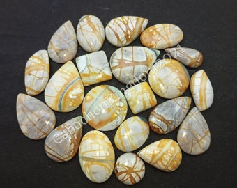 May include: A collection of 17 natural stone cabochons in various shapes and sizes. The stones are a mix of white, gray, and yellow with brown and orange veins. The cabochons are perfect for jewelry making or other craft projects.