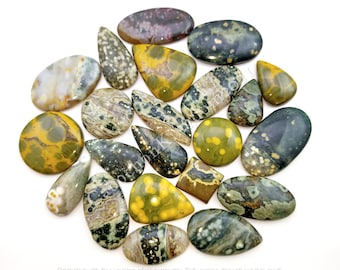 May include: A collection of 17 green, yellow, and brown ocean jasper cabochons. The cabochons are various shapes and sizes, including teardrop, oval, and round.