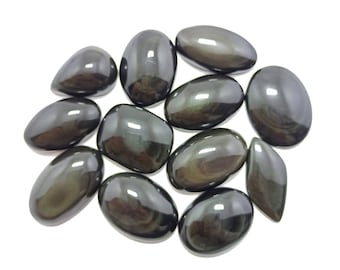 Könnte beinhalten: Eine Sammlung von 12 glatten, schwarzen Obsidian-Steinen mit schimmerndem, irisierendem Effekt. Die Steine sind oval und tropfenförmig.