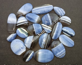 May include: A collection of 18 blue and black banded opal cabochons. The cabochons are oval shaped and have a smooth, polished finish.