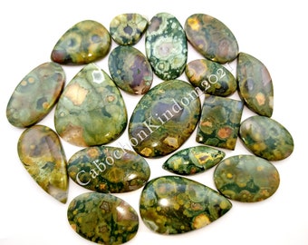 May include: A collection of 15 green, brown, and white ocean jasper cabochons. The cabochons are various shapes and sizes, including oval, teardrop, and rectangular.