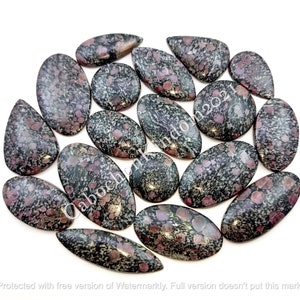 Peut inclure: Une collection de 17 cabochons de forme ovale et en goutte, chacun avec un motif unique de noir, gris et rose. Les pierres sont polies et ont une finition lisse et brillante.