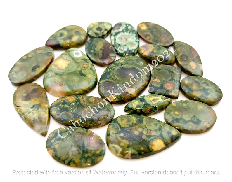 May include: A collection of 15 green, brown, and yellow ocean jasper cabochons. The cabochons are all different shapes and sizes, and they have a variety of patterns. The cabochons are all polished and have a smooth, shiny finish.