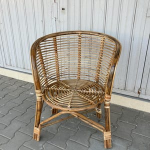 K&ouml;nnte beinhalten: Ein brauner Korbstuhl mit einem runden Sitz und einer abgerundeten R&uuml;ckenlehne. Der Stuhl ist aus nat&uuml;rlichem geflochtenem Rattan gefertigt und hat ein schlichtes, elegantes Design.