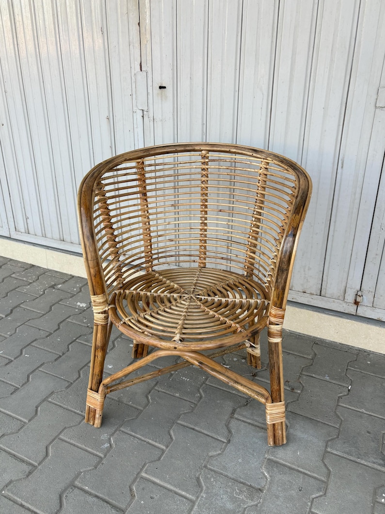 K&ouml;nnte beinhalten: Ein brauner Korbstuhl mit einem runden Sitz und einer abgerundeten R&uuml;ckenlehne. Der Stuhl ist aus nat&uuml;rlichem geflochtenem Rattan gefertigt und hat ein schlichtes, elegantes Design.