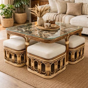 May include: A square coffee table with a glass top and a dark brown rattan frame, featuring four matching square ottomans with cream-colored upholstered cushions that tuck neatly underneath the table frame for compact storage.