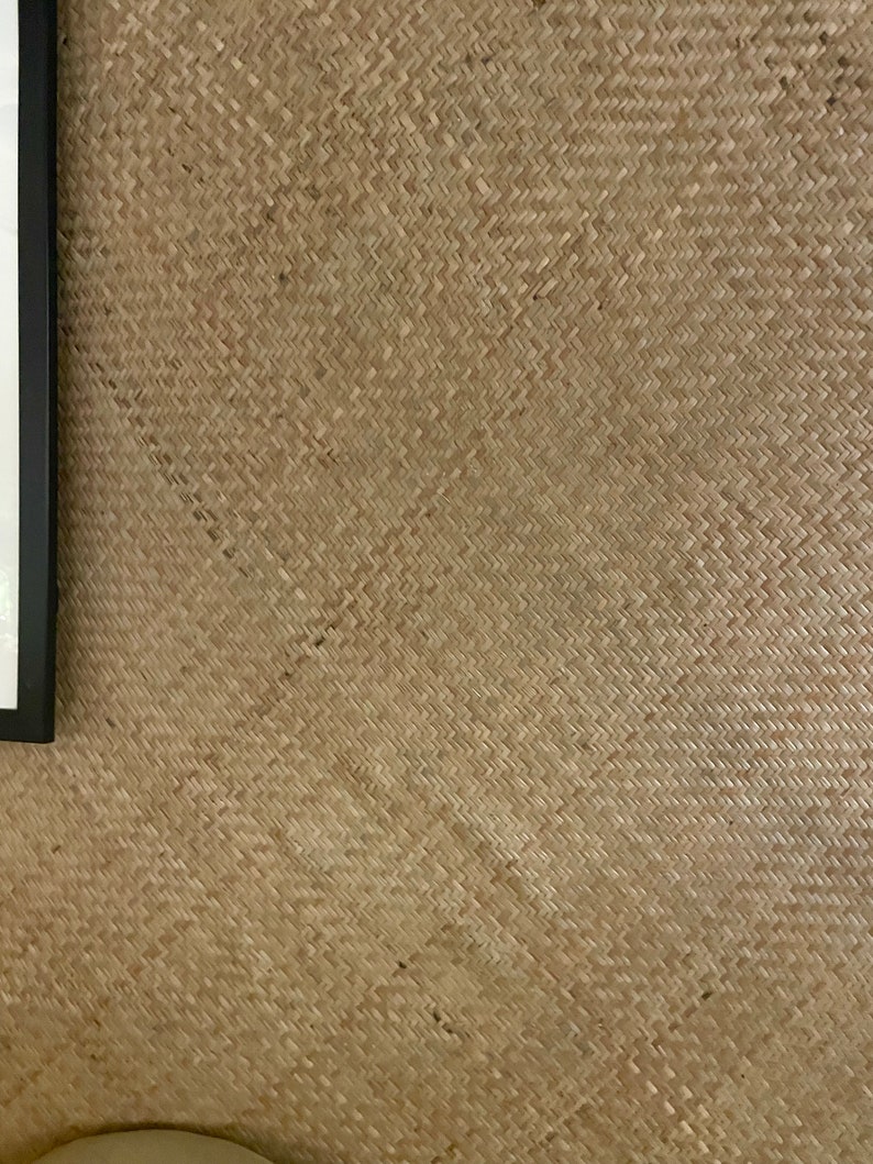May include: A close-up of a woven wall covering made of natural materials. The woven pattern is a diagonal weave with a light brown colour.