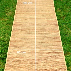 Pu&ograve; includere: Un tappetino intrecciato naturale in paglia, che misura 61 cm per 196 cm. Il tappetino &egrave; di colore marrone chiaro e ha una trama intrecciata.