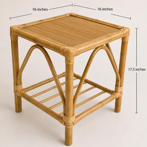 May include: A square bamboo side table with a slatted top and a lower shelf featuring five horizontal sticks. The table measures 16 inches in width, 16 inches in depth, and 17.5 inches in height, with arched supports connecting the four legs.
