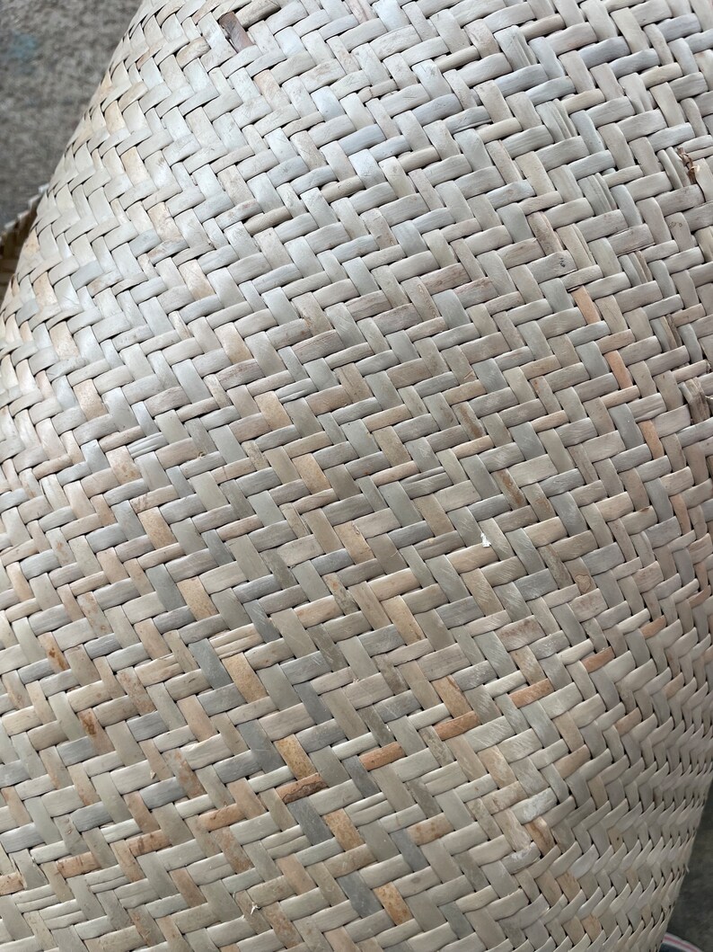 May include: Close-up of a woven basket made from natural materials. The basket is light brown in colour and has a tightly woven pattern.