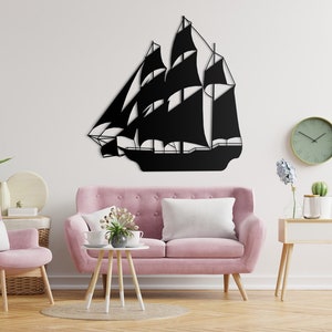 May include: Black metal wall art depicting a sailboat with a white background. The art is displayed on a white wall above a pink sofa in a living room setting.
