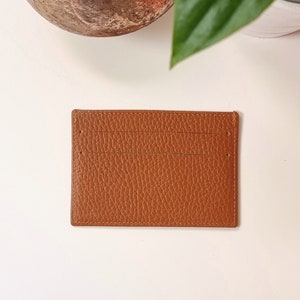 leather card holder in black color. This minimalist cardholder handmade with genuine leather, very soft. It has two card slots on each side and an additional central compartment for tickets or bills.
