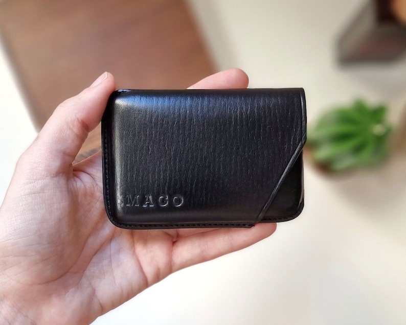 Custom black leather card holder with initials MAGO and minimalist design.