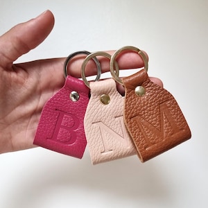 Three mini leather keychains in pink, beige, and brown. Personalized gifts for women.