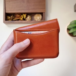 open leather card holder, shown up close and cards can be seen inside. This card holder is a high quality card holder with excellent finishes, perfect for gift.