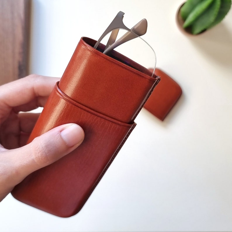 leather eyeglasses case open and held in one hand, you can see a little of the inside of the case.