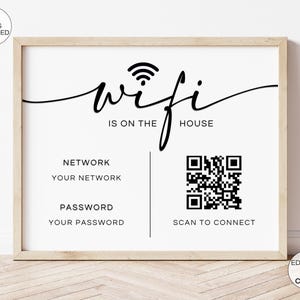 Könnte beinhalten: Ein gerahmtes Schild mit den Worten "wifi is on the house" in schwarzer Schrift. Darunter sind "Network" und "Password" mit Platz für Details sowie ein QR-Code zum Scannen aufgeführt. Das Schild befindet sich in einem hellen Holzrahmen.