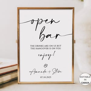 Può includere: Un cartello stampabile con una cornice dorata che dice "open bar" in corsivo. Il testo sottostante recita "The drinks are on us but the hangover is on you enjoy!" con i nomi "Amanda + Steve" e la data "07.10.2025" in basso. Il cartello è etichettato "Editable in Canva".