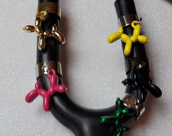 May include: A black stethoscope with five colorful balloon animal charms. The charms are in the shape of a dog, a star, a flower, a heart, and a butterfly. The charms are attached to the stethoscope with silver rings.