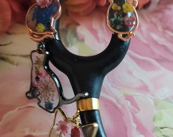 May include: Four gold cat charms with pressed flowers inside. The charms are attached to a black stethoscope.