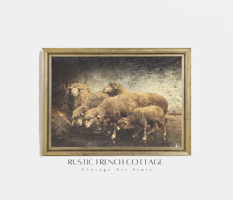 May include: A framed painting of a group of sheep in a barn. The sheep are brown and white and are standing in a group. The painting is set against a dark background with a light blue sky in the distance. The painting is framed in a gold frame.