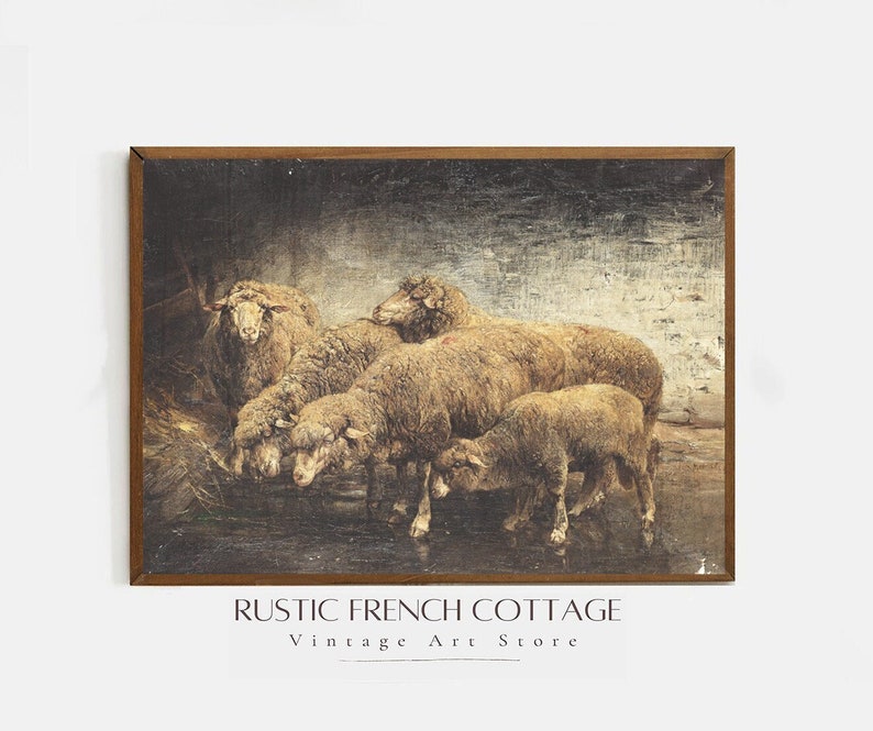 May include: A vintage framed print of a group of sheep in a field. The sheep are brown and white and are standing in a field of green grass. The print is framed in a brown wooden frame. The text "RUSTIC FRENCH COTTAGE Vintage Art Store" is at the bottom of the print.