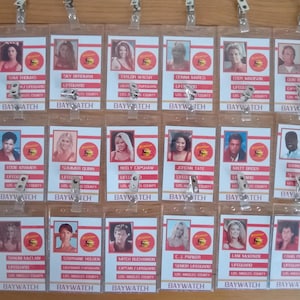 May include: A collection of 30 red, white, and blue plastic ID badges with a red lifeguard logo and the text "BAYWATCH" on each badge. Each badge features a different character from the TV show Baywatch.
