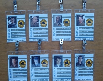 May include: Eight white plastic ID badges with black text and images of people. The badges are labeled "RMY-23" and include the name, rank, and post of each person. The text on the badges reads "Lewis and Clark".