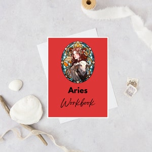 May include: A red workbook with a stained glass illustration of a woman with a ram. The title "Aries Workbook" is printed in black.