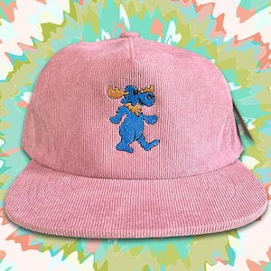 May include: A pink corduroy baseball cap with an embroidered blue moose with orange antlers.