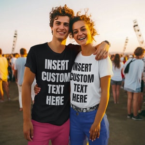 May include: A black t-shirt and a white t-shirt with the text "INSERT CUSTOM TEXT HERE" in a bold, sans-serif font. The black shirt is paired with pink pants, and the white shirt is paired with blue pants. The shirts are worn by two people.