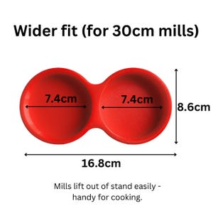 May include: A red double-holder stand for mills with a wider fit for 30cm mills. The stand features two circular openings each measuring 7.4cm in diameter. The total width is 16.8cm and the height is 8.6cm. Text reads: Wider fit (for 30cm mills).