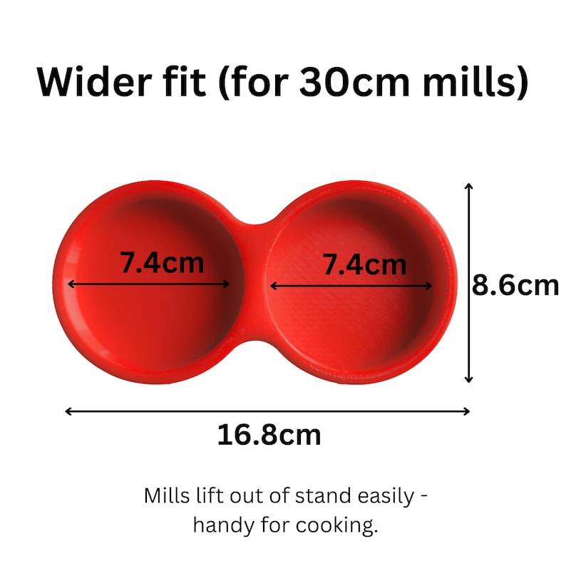 May include: A red double-holder stand for mills with a wider fit for 30cm mills. The stand features two circular openings each measuring 7.4cm in diameter. The total width is 16.8cm and the height is 8.6cm. Text reads: Wider fit (for 30cm mills).