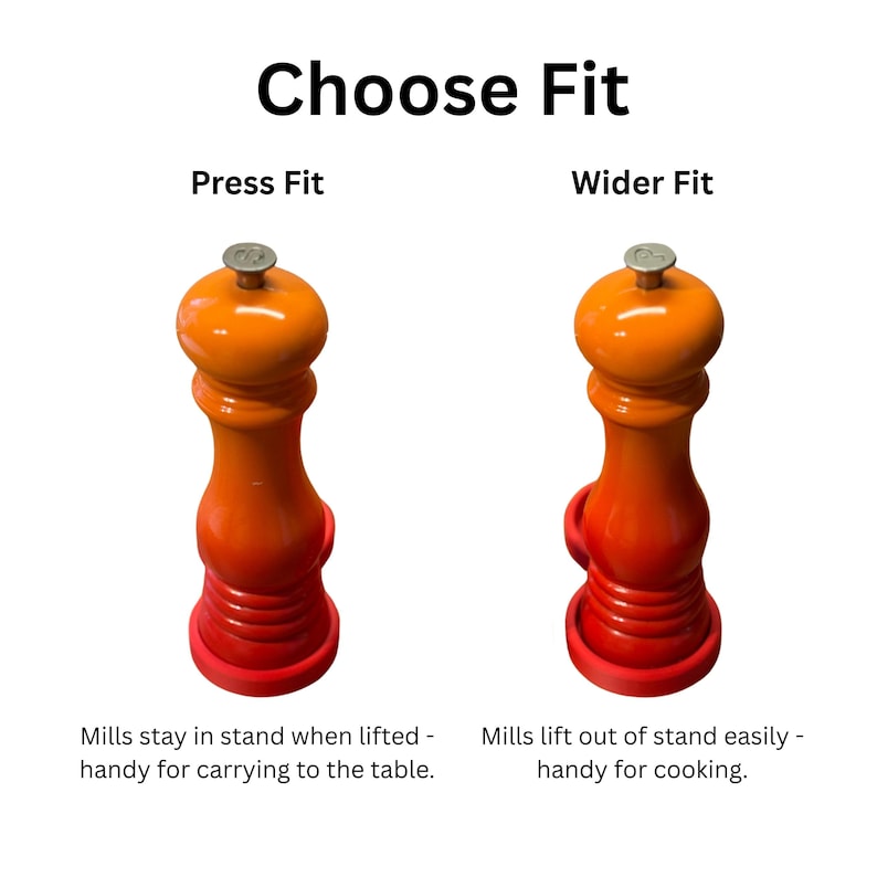 May include: Two orange pepper mills with silver-colored knobs, each resting in a red circular stand. The text reads Choose Fit, Press Fit, Wider Fit, Mills stay in stand when lifted - handy for carrying to the table, and Mills lift out of stand easily - handy for cooking.
