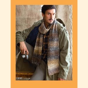 Puede incluir: Un hombre con una chaqueta verde con capucha, una camisa a cuadros y una bufanda a rayas marrón y gris. Está sosteniendo una cámara en su mano.