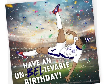 Può includere: Un biglietto di auguri per un compleanno con un'illustrazione a cartoni animati di un calciatore che calcia un pallone in aria. Il calciatore indossa una maglia bianca con dettagli blu e un cappello da festa. Lo sfondo è uno stadio con coriandoli che cadono. Il testo sulla carta dice "Have an Un-Believable Birthday!"