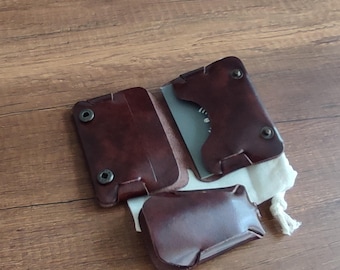 May include: A brown leather wallet with multiple compartments and a snap closure. The wallet is folded and lying on a wooden surface.