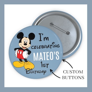 May include: A blue and white button with a cartoon image of Mickey Mouse. The button says "I'm Celebrating Mateo's 1st Birthday".