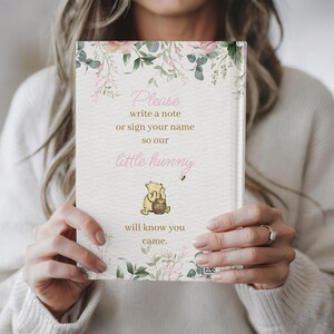May include: A white card with a floral design and a Winnie the Pooh illustration. The card says "Please write a note or sign your name so our little hunny will know you came."