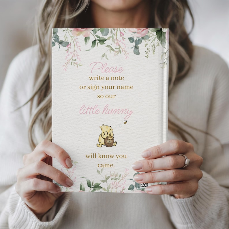 May include: A white card with a floral design and a Winnie the Pooh illustration. The card says "Please write a note or sign your name so our little hunny will know you came."