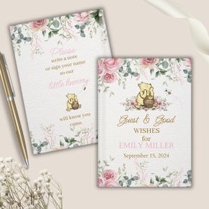 May include: Two floral guest books with Winnie the Pooh illustrations. The first book says "Please write a note or sign your name so our little hunny will know you came." The second book says "Guest & Good Wishes for Emily Miller September 15, 2024".