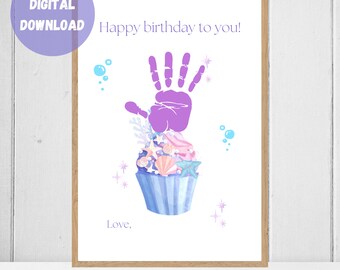 May include: A printable birthday card featuring a purple handprint in the shape of a cupcake with seashells, starfish, and coral decorations. The text "Happy birthday to you!" and "Love," are included.