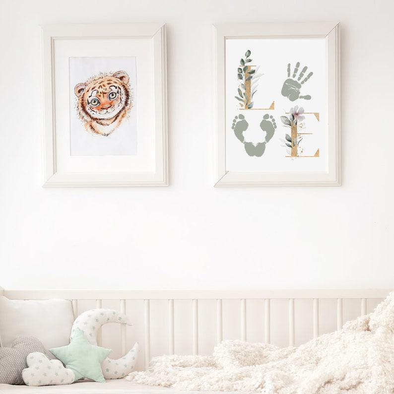 May include: Two framed prints, one with a watercolor illustration of a tiger cub and the other with a handprint and footprints forming the word "LOVE" with floral accents.